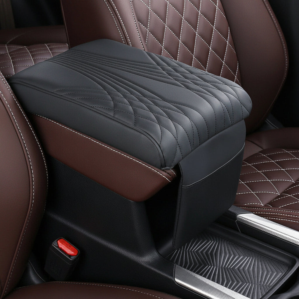 A black car center console armrest cover with quilted stitching, shown installed on a brown leather car seat.