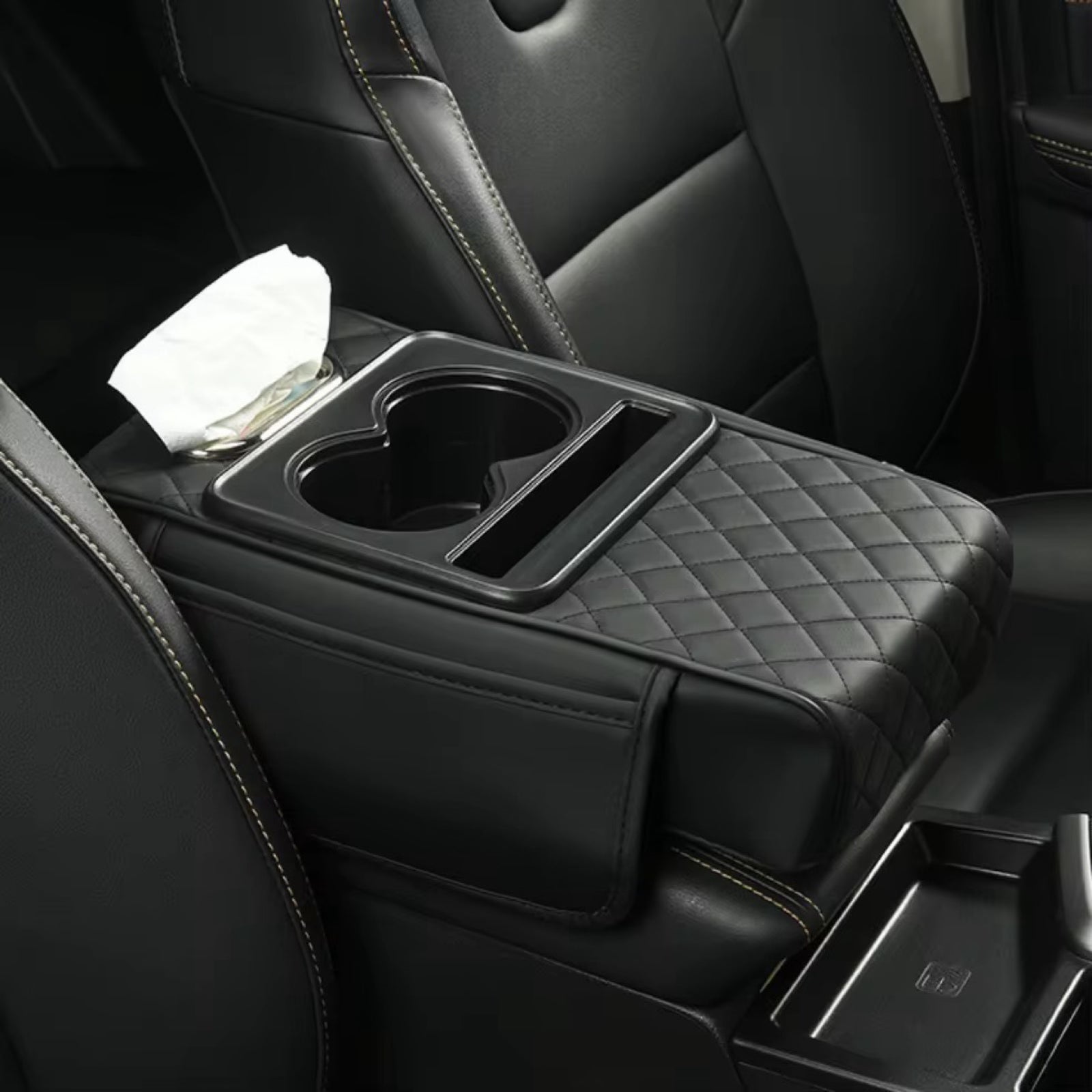 Car armrest with cup holder and tissue holder in a black leather interior.